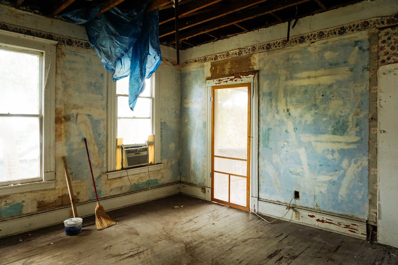 creative-03 An empty room in an abandoned house with peeling walls and construction tools.